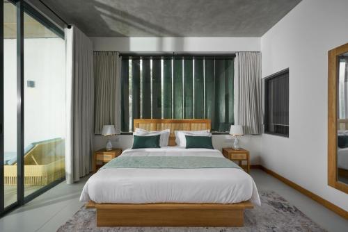 a bedroom with a large bed and a large window at Lord's Haputale in Haputale