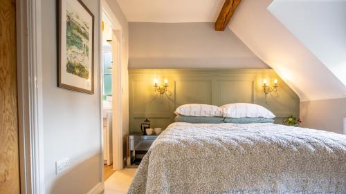 un dormitorio con una cama con dos almohadas en Inglenook Cottage, en Charlbury
