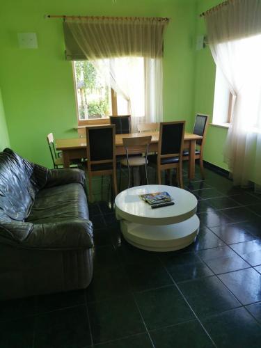 a living room with a couch and a table at Ģimenes māja “Rukši” in Dokupe