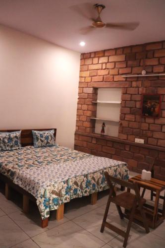 a bedroom with a bed and a brick wall at Mordhwaj in Jodhpur