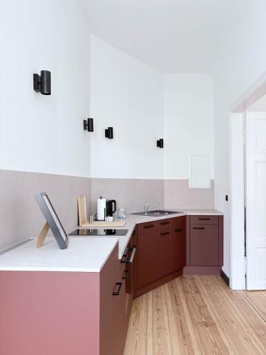 a kitchen with brown cabinets and a white counter top at Studios am Kniepertor in Stralsund
