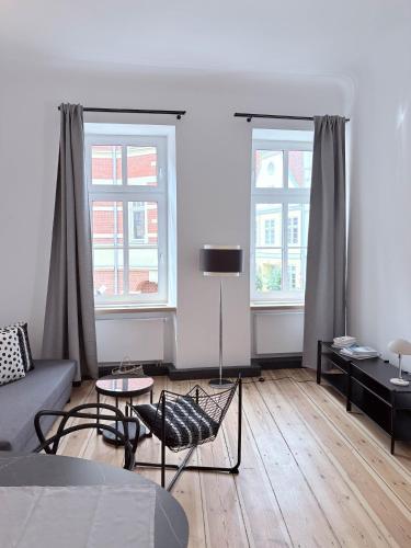 a living room with a couch and two windows at Studios am Kniepertor in Stralsund