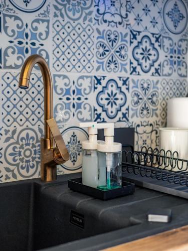 a sink with two bottles and a faucet in a bathroom at Pod Lasem Apartamenty in Łukęcin