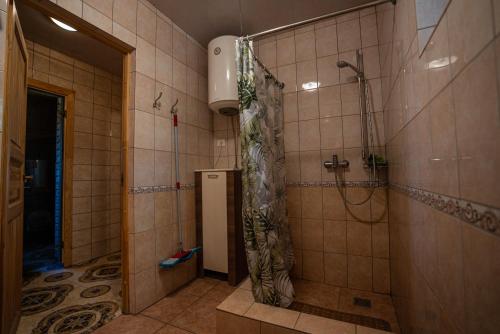 a bathroom with a shower with a shower curtain at Namelis su pirtele in Druskininkai