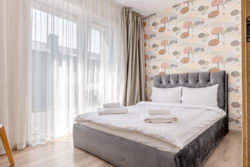 una camera da letto con un letto grande con una grande finestra di Mill Central a Palanga