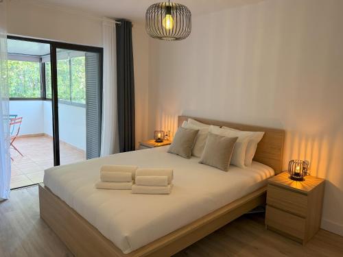 una camera da letto con un letto con due asciugamani sopra di Modern Condo with AC and Private Balcony - Go4Portugal ad Albufeira