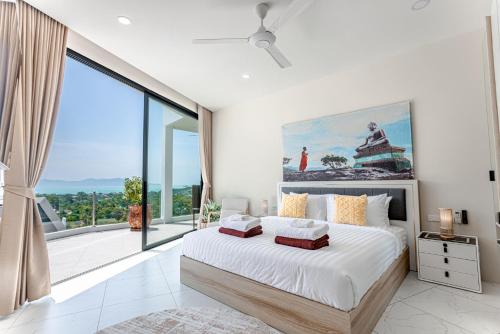 a bedroom with a large bed and a large window at Villa La Concha - Ideal for Families in Ban Khlong Mae Nam