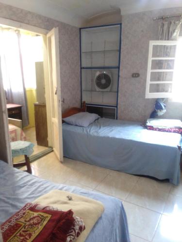 a bedroom with two beds and a window at شقة بغرفة ثلاثية in Alexandria