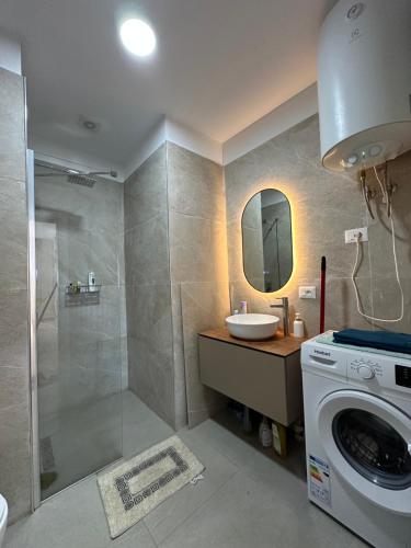 un bagno con lavandino e lavatrice di Kozy Studio Apartment a Durrës