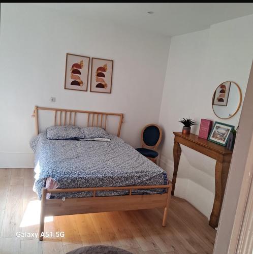 une chambre avec un lit et une table en bois dans l'établissement Tulipe21, à Dijon