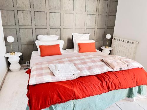 - une chambre dotée d'un grand lit avec des oreillers orange et blancs dans l'établissement Alberta, à Béziers