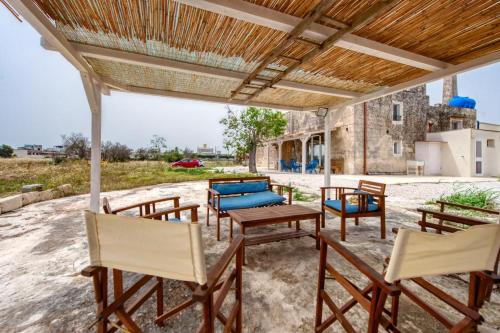 a group of chairs and tables on a patio at Casolare Giardino Aiarella-Assunta in Merine