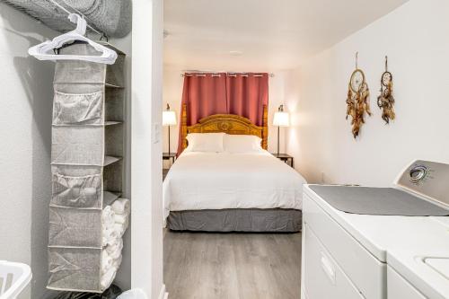 a bedroom with a bed and a red curtain at Less Than 1 Mi to ENMU Pet-Friendly Home in Portales! in Portales