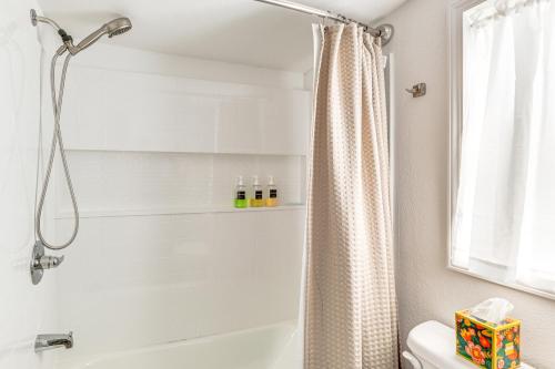 a bathroom with a shower curtain next to a tub at Less Than 1 Mi to ENMU Pet-Friendly Home in Portales! in Portales