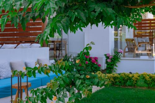 a garden with chairs and a tree and flowers at Sentimento Sea Breeze in Skala Prinou