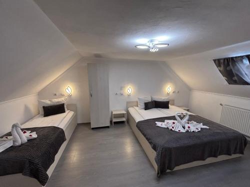 a bedroom with two beds with towels on them at Anita Vendégház Korond in Ascio