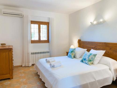 サン・ジョセップ・デ・サ・タライアにあるVilla Taridaの白いベッドとタオルが2枚置かれた寝室