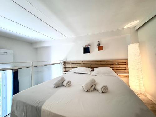 une chambre avec un grand lit blanc avec deux oreillers dans l'établissement ApartHotel Riviera - Duplex de la Buffa - 100m promenade des Anglais, à Nice
