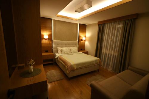 a small bedroom with a bed and a couch at Apartment MonteBreza Spa in Kolašin