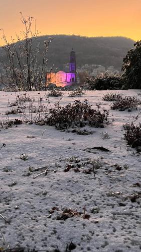 a light house in the snow with a lighthouse in the background at KITTERLELODGE Suite 1 à 4 personnes avec vue in Guebwiller