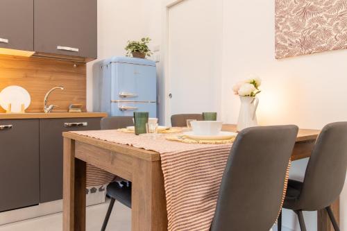 a kitchen with a table with chairs and a blue refrigerator at La Corte - Monza Apartments in Monza