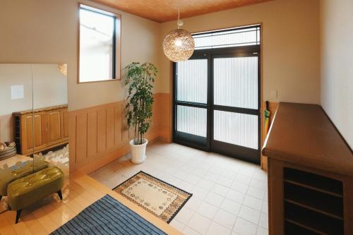 a living room with a door and a potted plant at 野波一棟貸古民家 