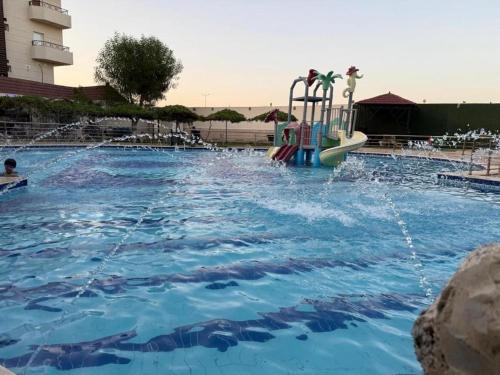 a swimming pool with a slide in the water at منتجع شاطي الاحلام in Yanbu