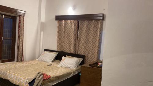 a small bedroom with a bed and a window at Surya hills Homestay in Patnitop