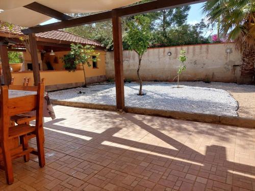 a patio with a table and a tree in a courtyard at Relax House Tropea Le Palme in Ciaramiti