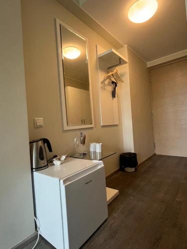 a kitchen with a white refrigerator and a mirror at Aisa Street apartments in Pärnu