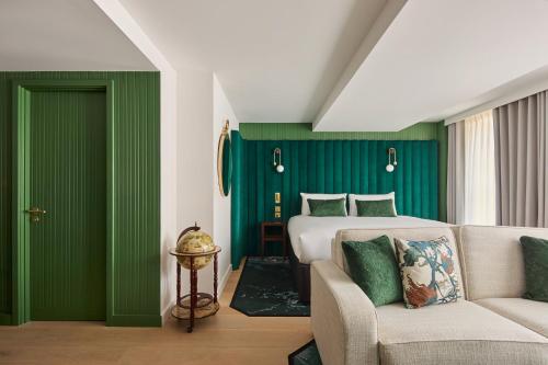 a bedroom with green walls and a bed and a couch at Hotel Indigo London Clerkenwell by IHG in London