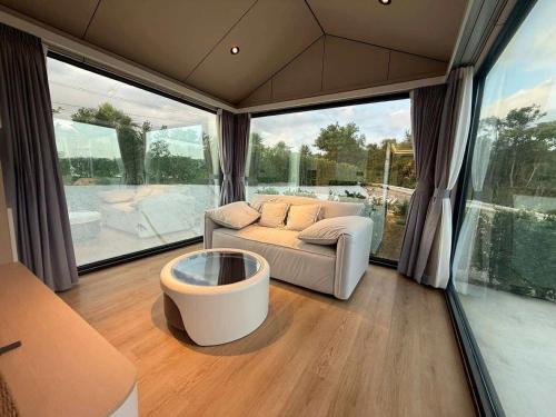 a living room with a couch and a large window at รามโรมวัลเลย์รีสอร์ท Ramrom Valley Resort in Ban Loeng