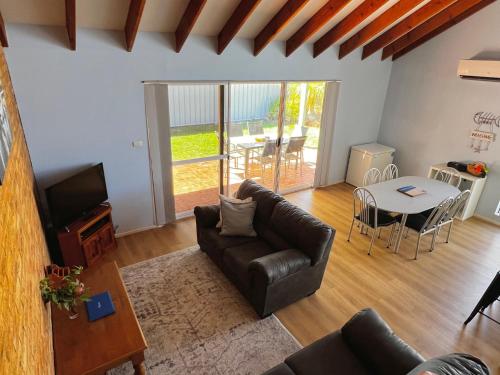 ein Wohnzimmer mit Sofa und Tisch in der Unterkunft Tropical Palms - Kalbarri, WA in Kalbarri