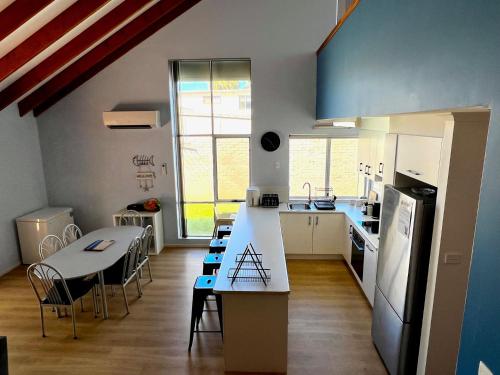 eine Küche und ein Esszimmer mit einem Tisch und einer Theke in der Unterkunft Tropical Palms - Kalbarri, WA in Kalbarri