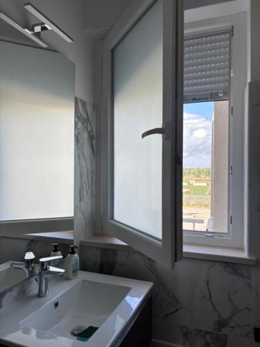 a bathroom with a sink and a window at Torvajanica Antonella in Torvaianica