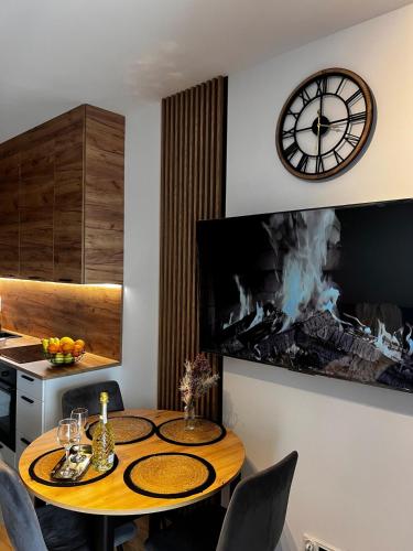 a kitchen with a table with a clock on the wall at Apartament Poznańska 1 in Suwałki