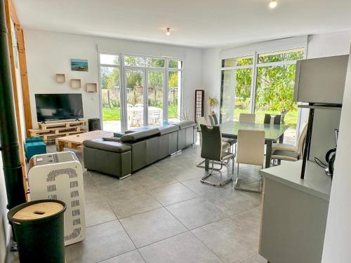 a living room with a couch and a table at Maison éco-chic 4 chambres proche Lac et Troyes jardin WiFi nigloland in Lusigny-sur-Barse