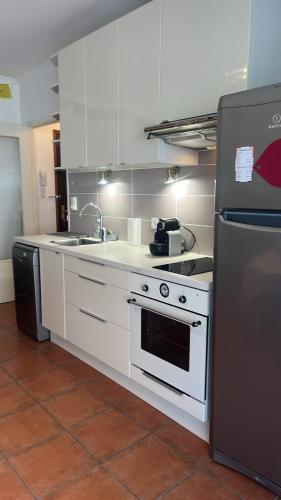 une cuisine avec une cuisinière et un réfrigérateur dans l'établissement Loft cosy au portes d'avignon, aux Angles (Gard)