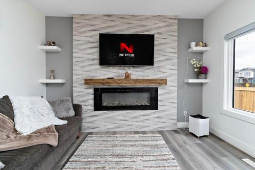 a living room with a fireplace and a tv at The Happy place - Luxurious, Cozy and Modern Home with Air-condition, Netflix, Free Parking close to Airport and West Edmonton Mall in Edmonton