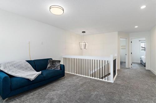 a living room with a blue couch and a bed at The Happy place - Luxurious, Cozy and Modern Home with Air-condition, Netflix, Free Parking close to Airport and West Edmonton Mall in Edmonton