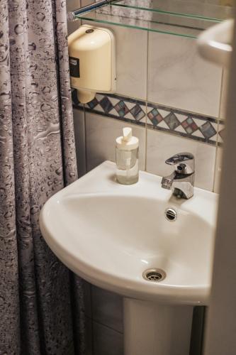 a bathroom with a white sink and a shower curtain at Villa14 - Noisy Party Hostel in Pärnu