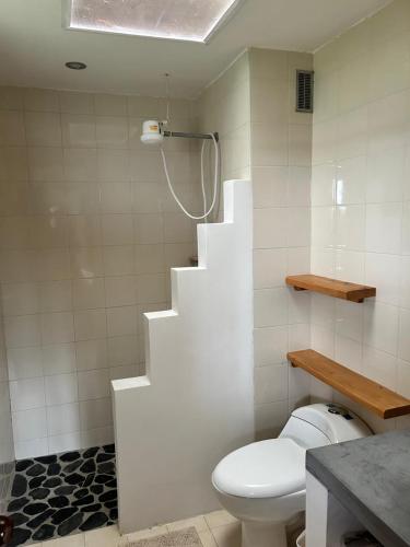 a bathroom with a white toilet and a staircase at Natural refuge Montenevoso in Sasaima