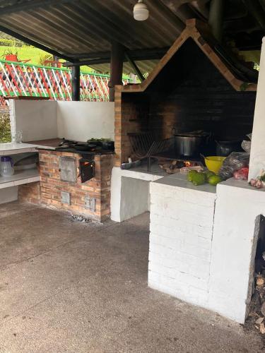 an outdoor kitchen with a grill with food on it at Natural refuge Montenevoso in Sasaima