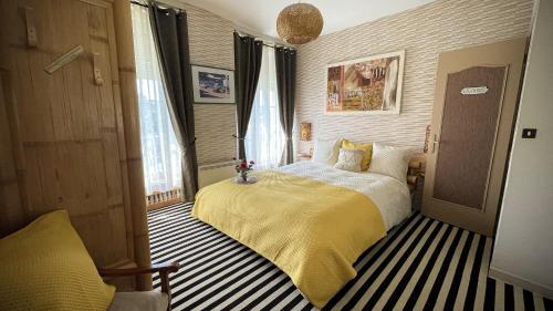 une chambre avec un lit avec une couverture jaune dans l'établissement Grand Gite historique confortable -Plages du D-DAY, à Ver-sur-Mer
