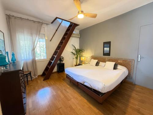 a bedroom with a large bed and a ladder at Agi El Xalet in Roses
