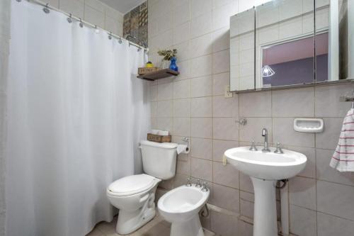 Un baño blanco con inodoro y lavabo. en Marea Patagonia, en Puerto Madryn