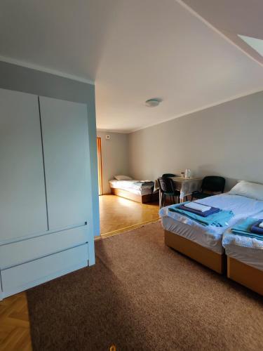 a bedroom with a bed and a dresser and a table at Pod bocianim gniazdem in Stary Folwark