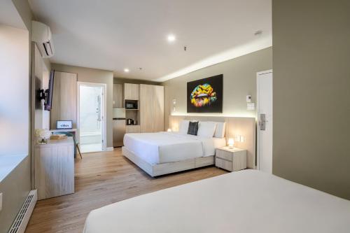 a bedroom with a large white bed and a desk at Olympia Hotel by Lodgo in Montréal
