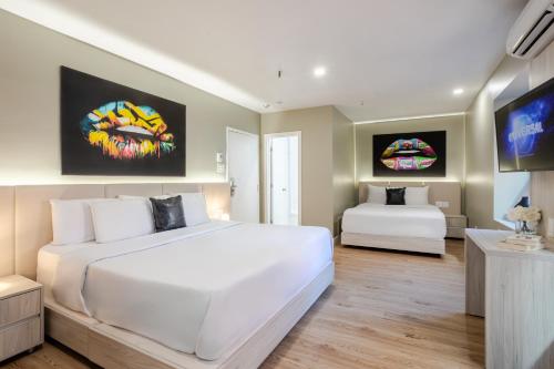 a bedroom with a large white bed and a flat screen tv at Olympia Hotel by Lodgo in Montréal