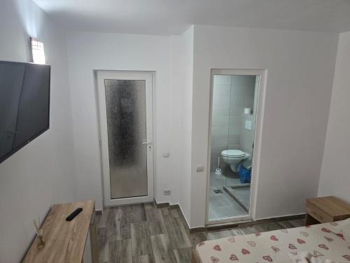 a white room with a bathroom with a toilet at Casa Stoian in Costinesti